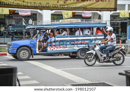 PHUKET, THAILAND - MAY 18, 2014:  Unidentified people travel around the city by local minibus or Songtaew Mai on May 18, 2014 in Phuket, Thailand.