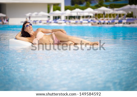Beautiful young woman having a rest on the pool