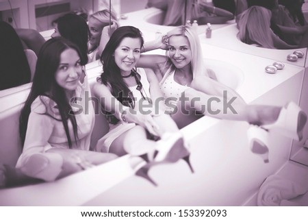 Three fashion model posing in a stylish room with bath. Special warm tuning.