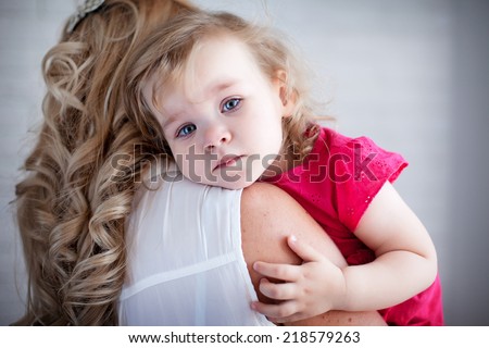 Young mother holding her crying baby girl