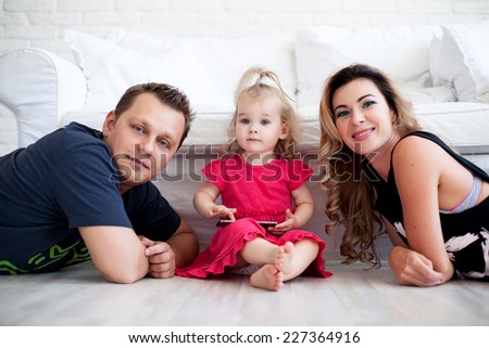 Mother and father posing while their daughter playing with phone