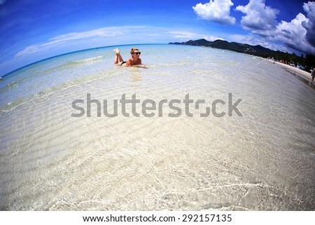 Beautiful model relaxing on the beach. Fish-eye effect.