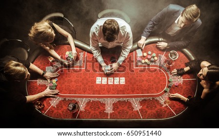 top view of men and women playing poker in casino