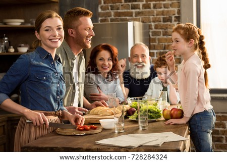 happy multigeneration family preparing dinner together in kitchen