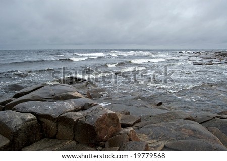 White sea (Russia) landscape with stones, rocks and gray clouds