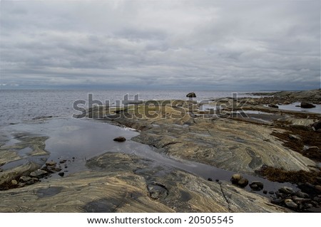 White sea (Russia) landscape with stones and gray clouds