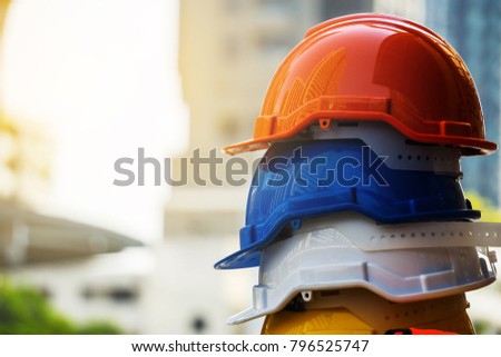 Orange, blue,  white and yellow hard safety helmet hat. Engineer, Construction and Safety Concept.\
Copy Space.