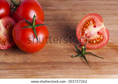 Red vine tomatoes on wooden chopping board for healthy eating and lifestyle choices
