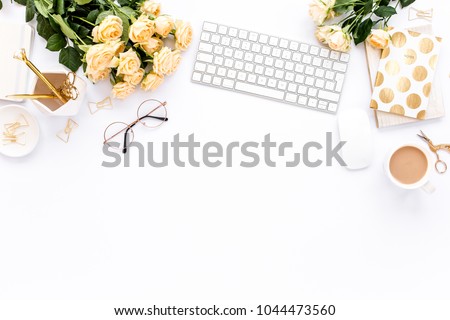 Female workspace with computer, roses flowers bouquet, golden accessories, diary, laptop, glasses on white background. Flat lay women's office desk. Top view feminine background.