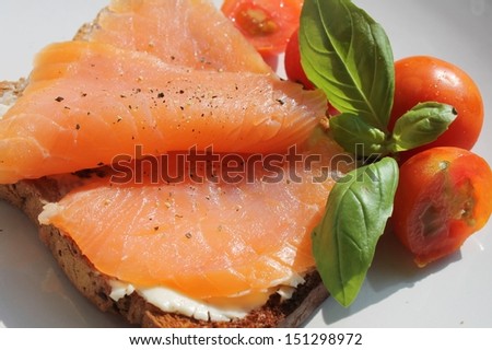 Healthy smoked salmon on toast with cream cheese, basil, and cherry tomato\'s