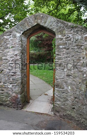 stone arch and door to garden with grass on other side