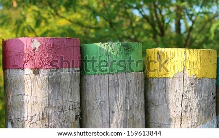 fence of house made from wood with painted colourful stripe at top tip