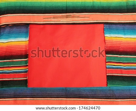 Traditional Mexican fiesta poncho rug in bright colors with sombrero background with copy space