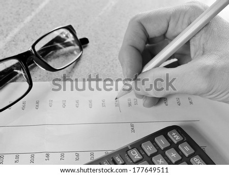 Bank statement with pencil hand and calculator glasses