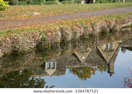 Reflection of House in River; Cotswold Village; Cheltenham; England; UK
