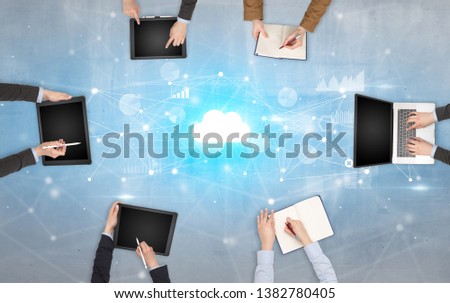 Group of people with devices in hands working on reports with online teamwork and cloud technology concept