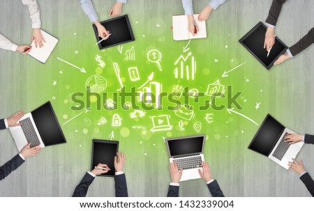 Group of people with devices in hands making reports together on laptop, tablet, notebook