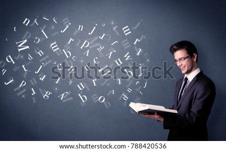 Casual young man holding book with white letters flying out of it