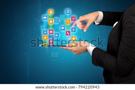 Female elegant hand holding tablet with colourful application icons