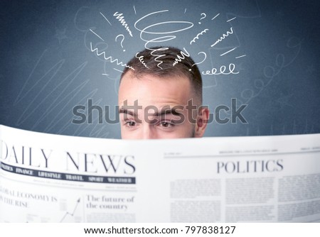 Confused businessman holding newspaper