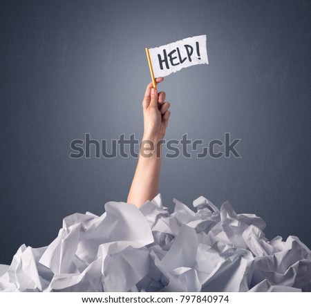 Female hand emerging from crumpled paper pile holding a white flag with help written on it