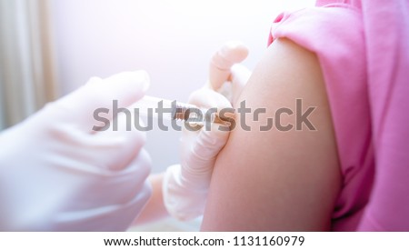 Close-up hand's doctor or nurses are vaccination to patient using the syringe injected upper arm for treated,Doctor giving an injection to a patient,Prophylactic HPV vaccination and anal cancer,