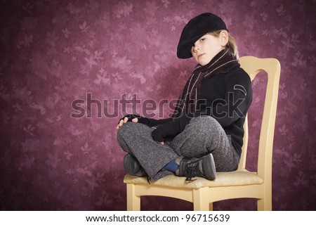 Cute kid with casual clothes in studio siting on chair