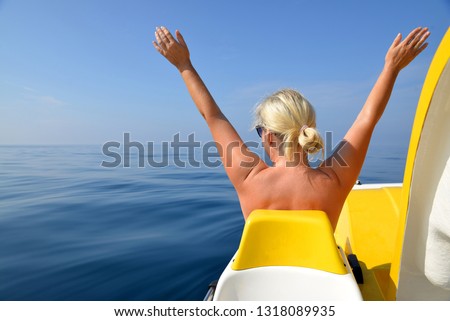 Happy woman on a pedal boat on water level in sunny day. Summer vacation by the sea.