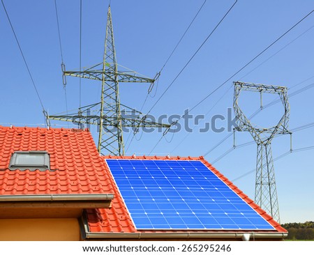 Solar panel on the roof of the house in the background high voltage pylons