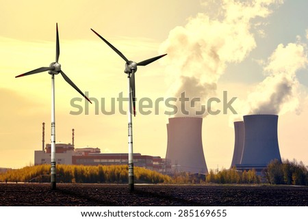 Nuclear power plant and wind turbines at sunset - Green energy concept
