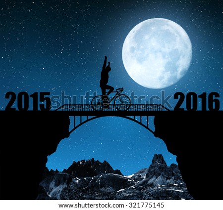 Cyclist riding across the bridge in night. Forward to the New Year 2016. \