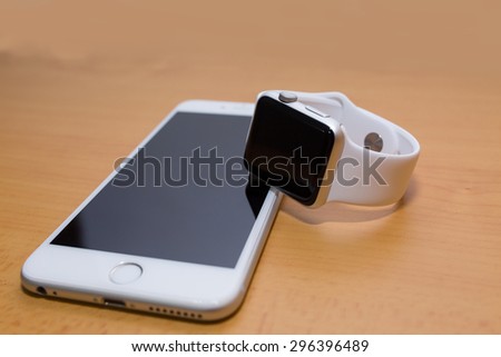 White Smart-phone And White Smart-watch.  on wood desk.