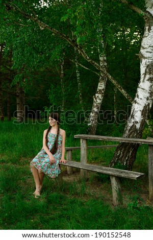 nice girl sitting in the forest on the wooden bench, vacation, holiday