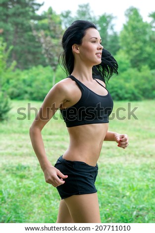 Female jogging outside in the park. Runners training outdoors