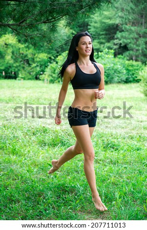 Female jogging barefoot outside in the park. Runners training outdoors