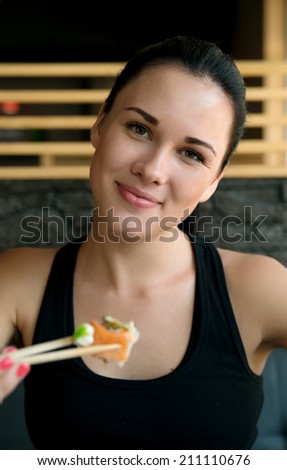 Young European  woman eating sushi in an Asian restaurant