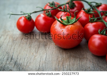 close up of fresh red delicious tomatoes  on an  old wooden tabletop background with place for text