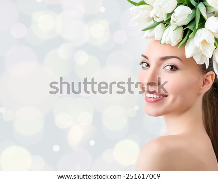 Portrait of beautiful young woman with flowers in hair. Bokeh. Place for text