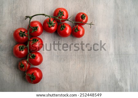 fresh red delicious tomatoes on an old wooden tabletop background with place for text