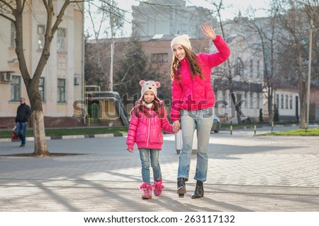 Two girls walking  in the city.  Adult and child, mother and daughter, two sisters walk on the street, spring. Facial expression. Casual style, sportswear, pink jackets.