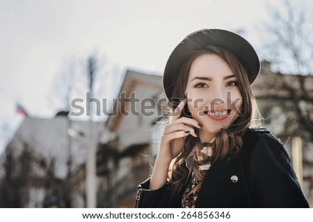 Beautiful brunette girl in casual clothes walking around the city. Fashion and city style. Facial expression.
