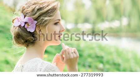 Portrait of beautiful young woman with spring flowers in hair. Make up and hair style. Wedding bride style.