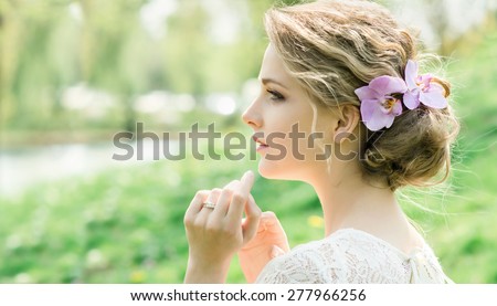 Portrait of beautiful young woman with spring flowers in hair. Make up and hair style. Wedding bride style.
