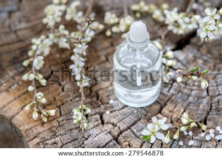 Spa and wellness setting with sea salt, oil essence, flowers and towels on wooden background. Relax and treatment therapy. Manicure and pedicure settings.  Spring season. Selective focus. Close up.