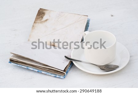 white cup and vintage notebook on a white wooden tabletop