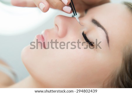 Eyelash Extension Procedure.  Woman Eye with Long Eyelashes. Lashes. Close up, selected focus.