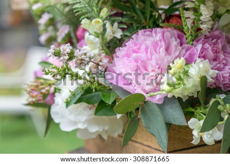 Bouquet of flowers in wooden box outdoors. Peony. Selective focus, close up. Space for text.