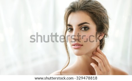 Beauty model with  natural make up, wet hair and fresh skin is posing front of the window. Youth and Skin Care Concept.  Make up and Hair. Morning.  Close up, selected focus.