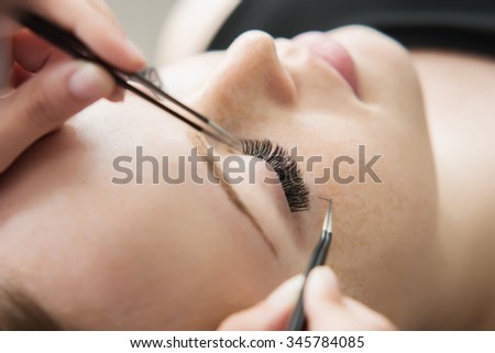 Eyelash Extension Procedure.  Woman Eye with Long Eyelashes. Lashes. Close up, selected focus. Shallow DOF.