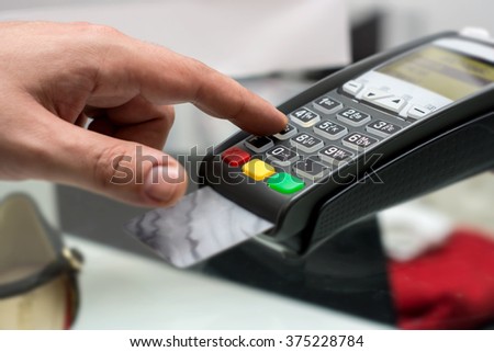Credit or debit card password payment. Customer hand is entering pin in shop or supermarket. Payment terminal keypad, pin.  Buy and sell products and service. Close-up, selective focus.